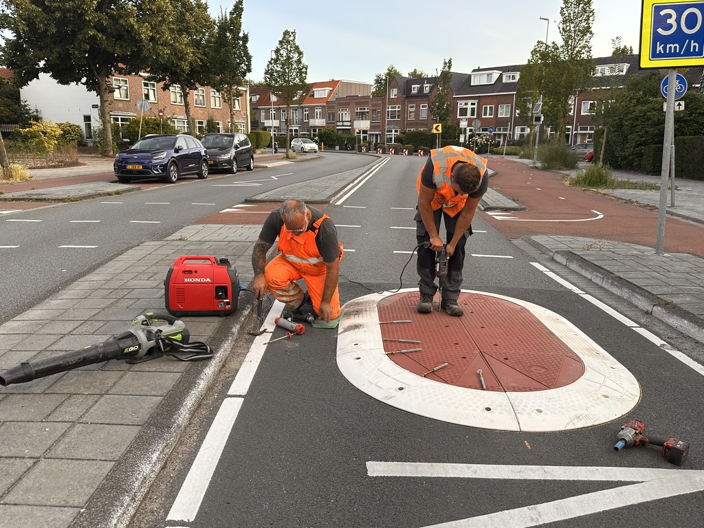 Vakmensen boren bevestigingsgaten bij de aanleg van een Berlijns kussen
