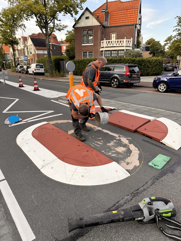 Vakmensen monteren de losse delen van een rood-wit Berlijns kussen